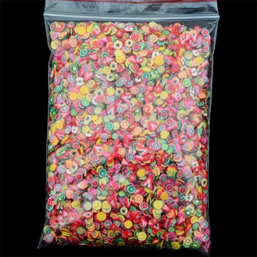 Assorted polymer clay fruit slices for nail art, 5mm diameter, 23 designs, in a bag, with nail decoration tools and stickers.