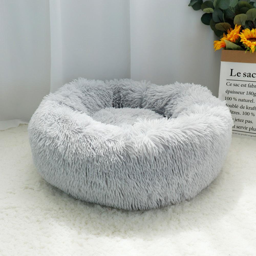 Brown fluffy calming dog bed by dev2-aff, round plush donut shape with orthopedic support for dogs, cats, and puppies.