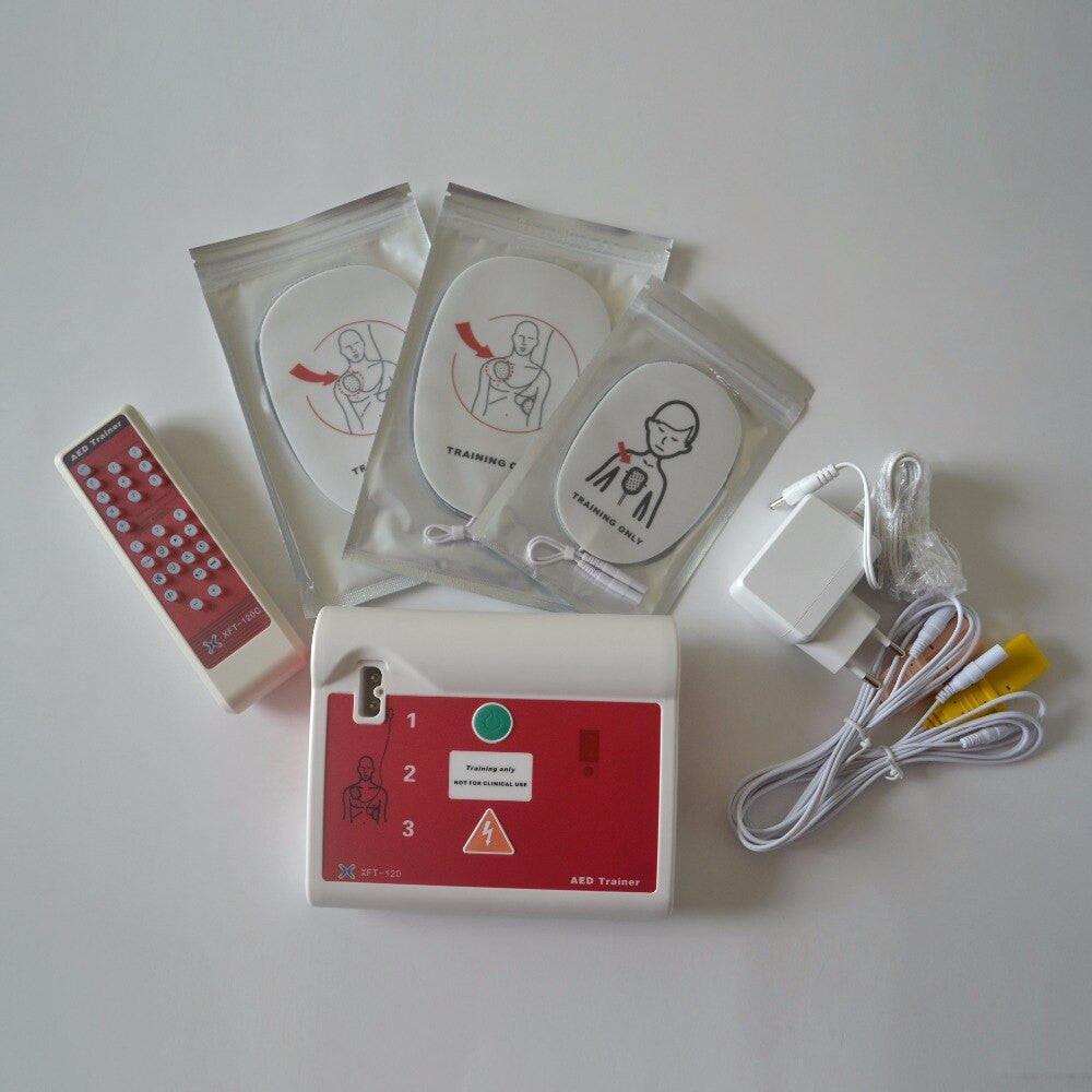 XFT-120C AED simulator trainer with electrode pads, used for CPR and first aid training in English and Russian.
