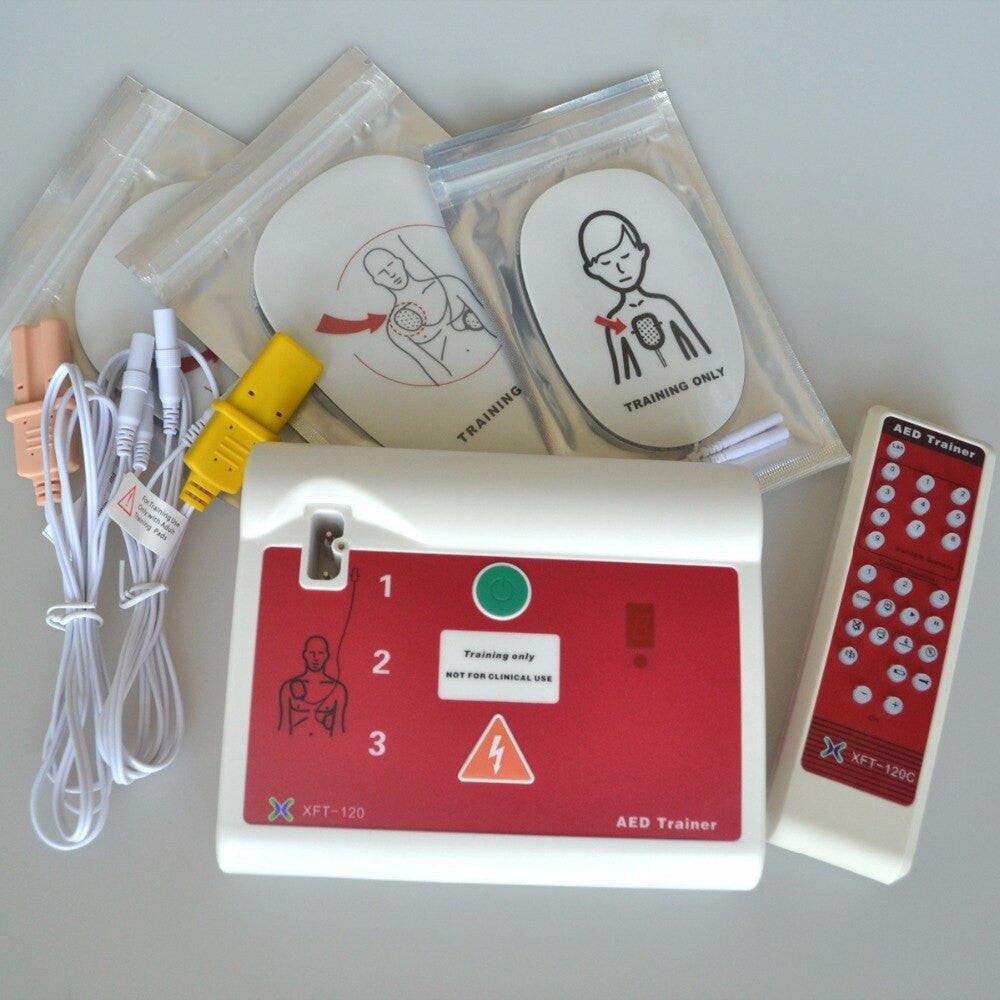 XFT-120C AED simulator trainer with electrode pads, used for first aid and CPR training in English and Russian.
