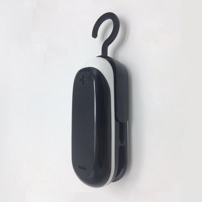White mini heat bag sealing machine by dev2-aff with sealing bags for food, plastic closure, portable sealer for kitchen packing.