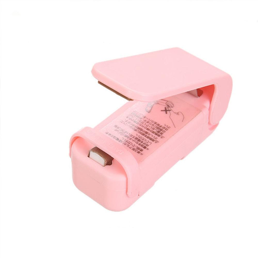 White mini heat bag sealing machine with sealer bags, portable thermal plastic food bag closure for kitchen packing use.